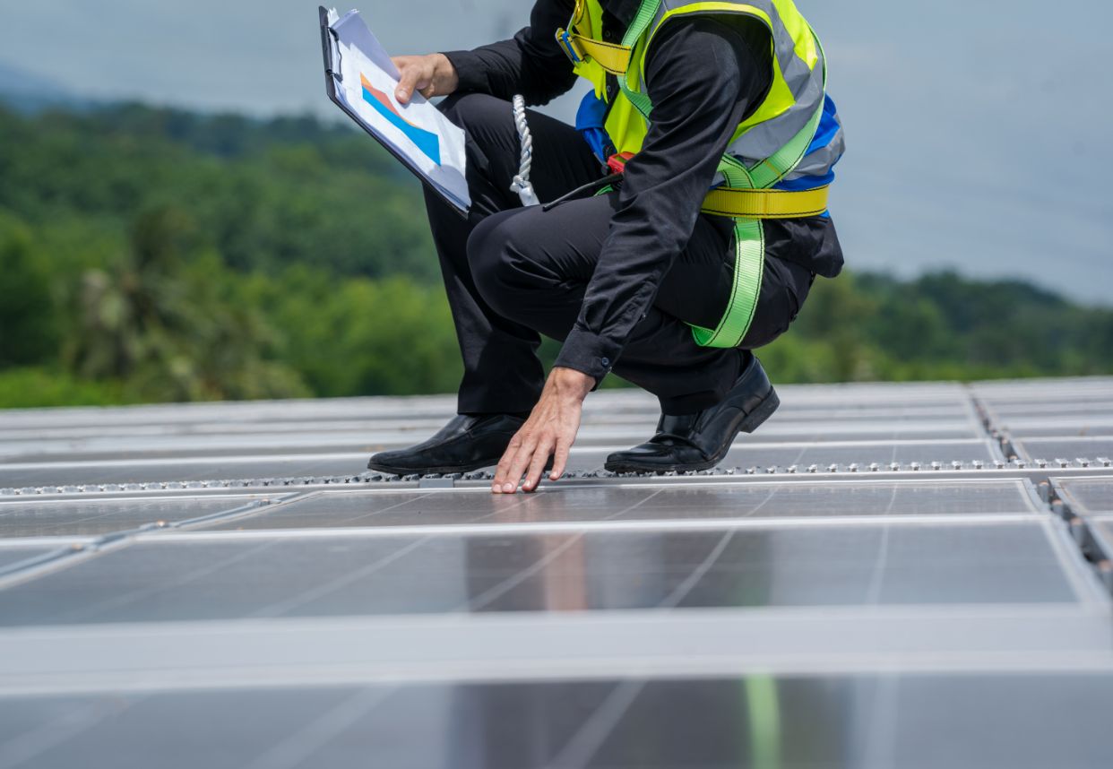 Mitarbeiter prüft und dokumentiert PV-Anlage